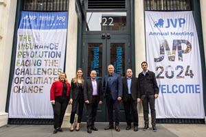 Six people stand in front of a building entrance with large banners that read "The Insurance Revolution: Facing the Challenges of Climate Change" and "JVP Annual Meeting 2024 Welcome." The doors have labels that say Margalit Startup City.