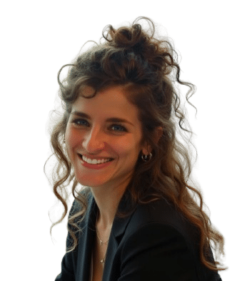 A woman with curly hair, wearing a black blazer and a watch, sits smiling at the camera against a plain background—capturing the signature portrait style of Or Nadav Argov.